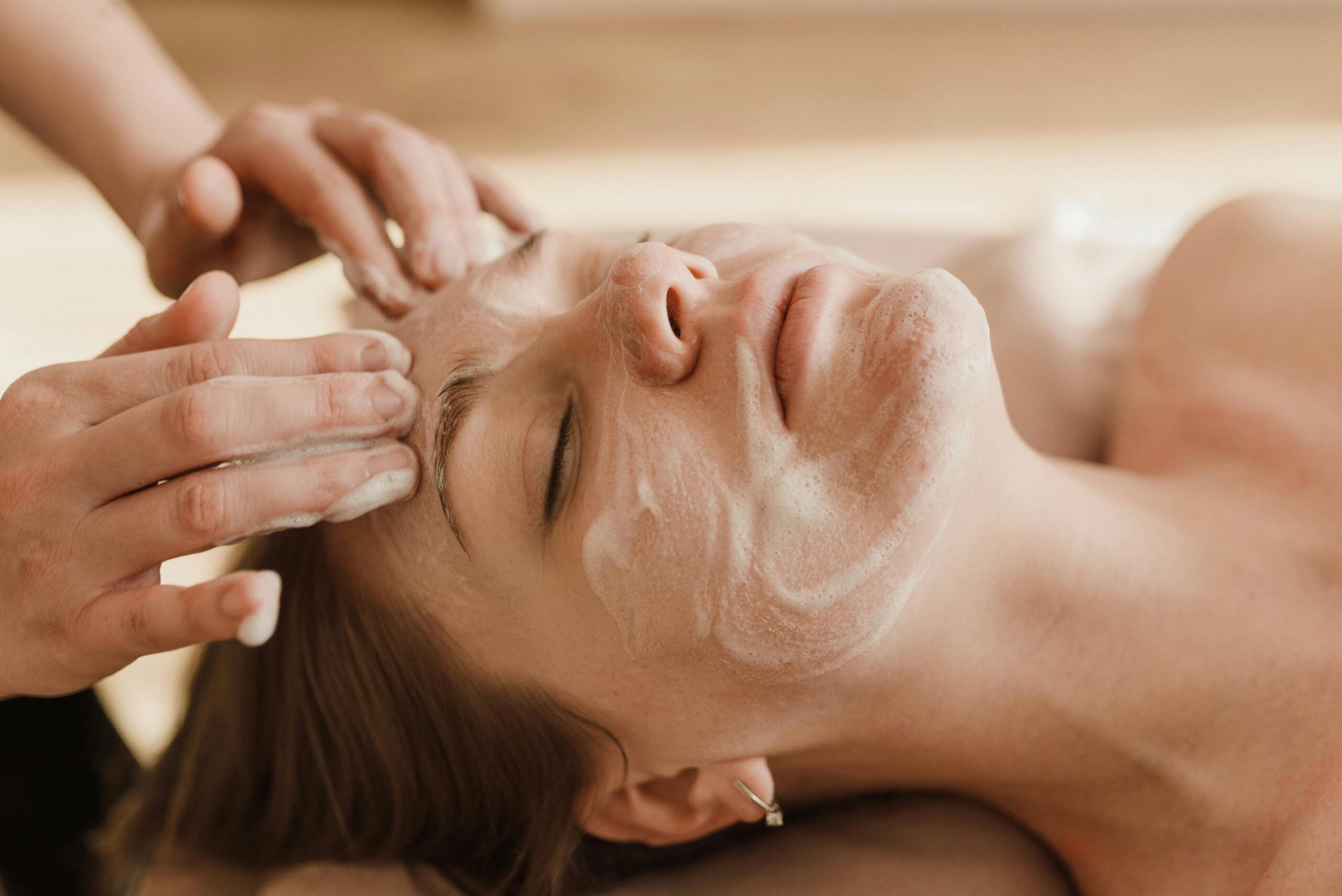 pexels-photo-6663368-6663368 A close-up of a woman receiving a soothing facial massage with a skincare mask.